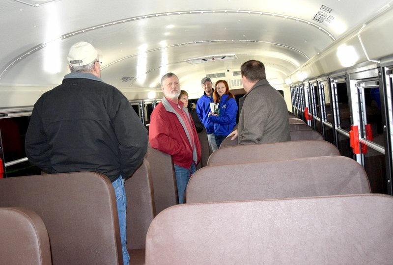 Photo by Mike Eckels Doug Holly (left) gives a tour of the new activity bus to members of the Decatur School Board on Dec. 19 in the parking lot at Decatur High. Board members and school officials taking the tour included Jeff Gravette (right, counterclockwise) Amy Brooks, Kevin Smith, Darleen Holly, Ike Owens and Holly.