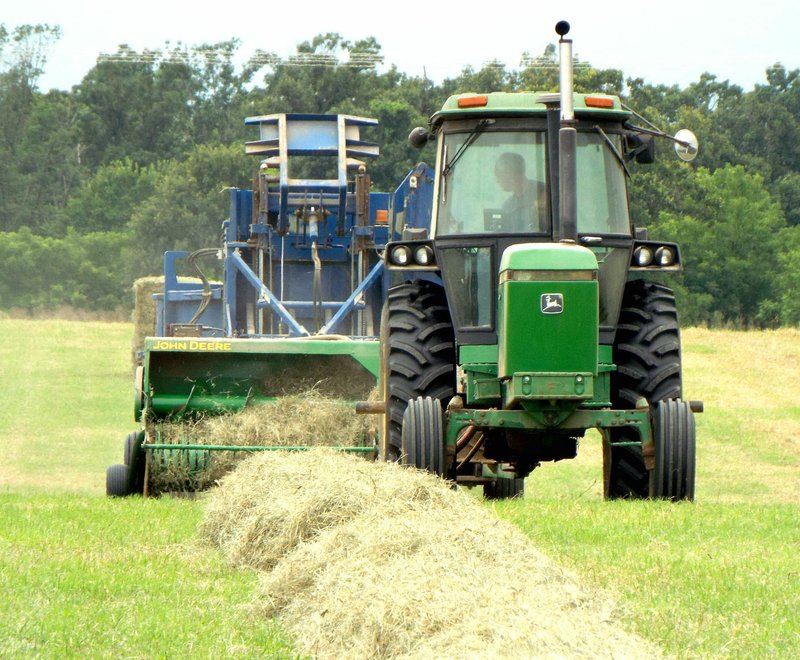 Photo by Randy Moll This farmer was busy baling hay on the property of Thomas and Rochelle Ritz, just southwest of Gentry on Thursday as the rain drops began to fall. Heavy rains last week made it difficult for farmers to cut hay and get it dried and baled before more thunderstorms hit. This week promises to be better haying weather, according to weather forecasts. &#8212; Reprinted from the July 20, 2016, issue.