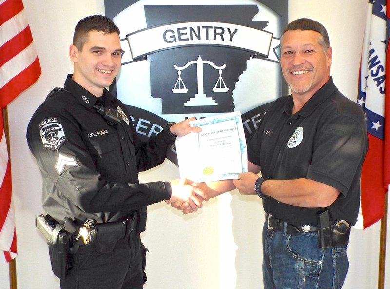 Photo by Randy Moll Kyle Thomas (left) received a certificate of promotion on Friday afternoon from Gentry Police Chief Keith Smith. Thomas was promoted to the rank of patrol corporal with the department.