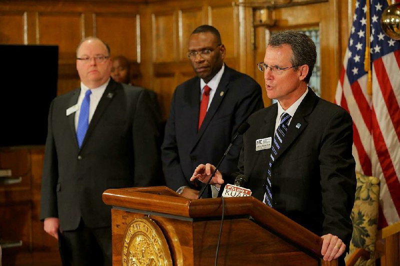 College of the Ouachitas President Steve Rook (left) and Henderson State University President Glen Jones (center) listen as National Park College President John Hogan speaks during a news conference announcing the formation of the Southern Arkansas Regional Alliance on Wednesday at the state Capitol in Little Rock.