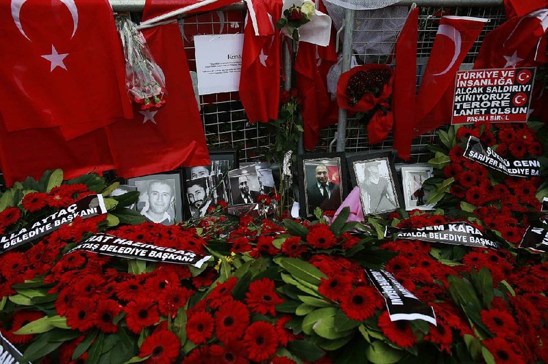 Floral tributes and Turkish flags along with photos of victims are displayed outside the Reina club Wednesday after the New Year’s attack in Istanbul.
