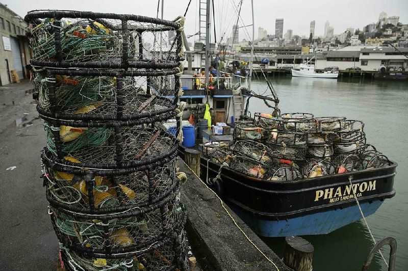 Crab pots sit on a processing pier and the back of a boat at Fisherman’s Wharf in San Francisco on Tuesday. Hundreds of fishermen kept their boats tied to docks Wednesday in a protest against a price of $2.75 a pound for Dungeness crab. 
