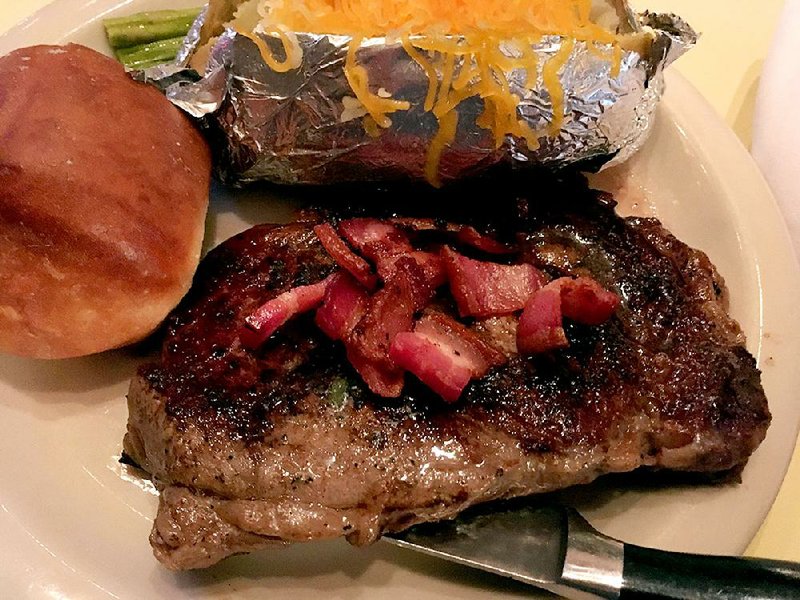 The small rib-eye steak comes topped with bacon, choice of potato (in this case, baked) and the green vegetable du jour (asparagus) at Terry’s Finer Foods the Restaurant. 