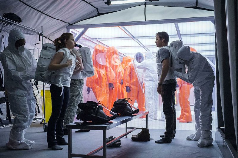 Linguist Louise Banks (Amy Adams) and military scientist Ian Donnelly (Jeremy Renner) suit up in preparation to meet “Abbott and Costello” in Arrival, a film that’s showing up on a lot of year-end “best of” lists.