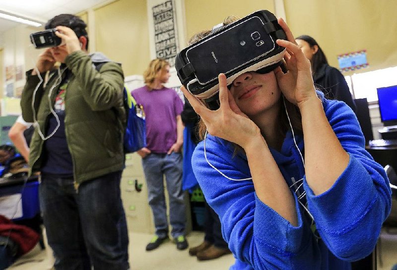 Kacie Skelton (right) and other Little Rock Central High School students try out virtual-reality headsets during a demonstration Thursday at the school.