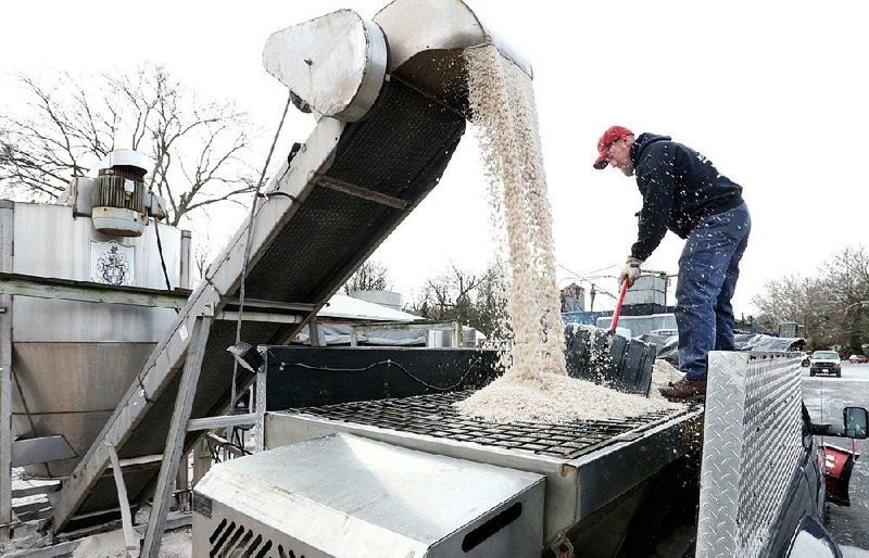 Tim Ritter, of Winchester, Va., uses a snow shovel to guide 4,000 pounds of salt being loaded into his spreader truck while preparing for the first measurable snowfall of the season Thursday.