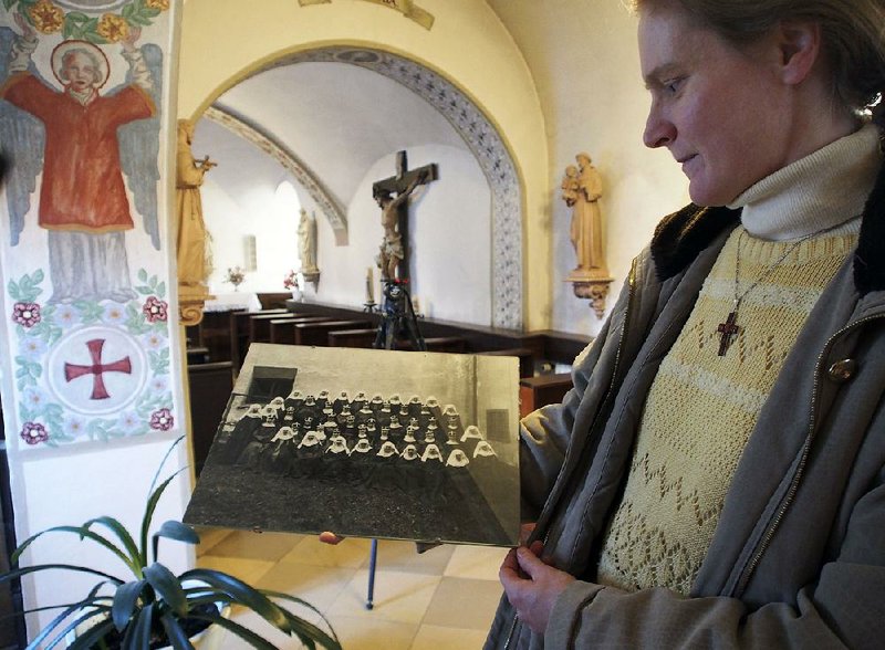 Postulant Claudia Schwarz holds an old photograph of Bridgettine nuns in the abbey in Altomuenster, Germany. The impending dissolution of the order’s 15th-century monastery is pitting scholars, who want access to its library, against Catholic church officials.