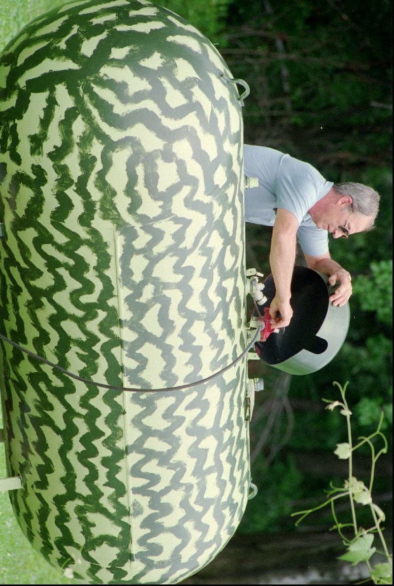 David Colcase checks his award winning watermelon in 2007. Colcase sold the seeds and turned the thing into a propane tank.Fayetteville-born Otus the Head Cat’s award-winning column of humorous fabrication appears every Saturday.