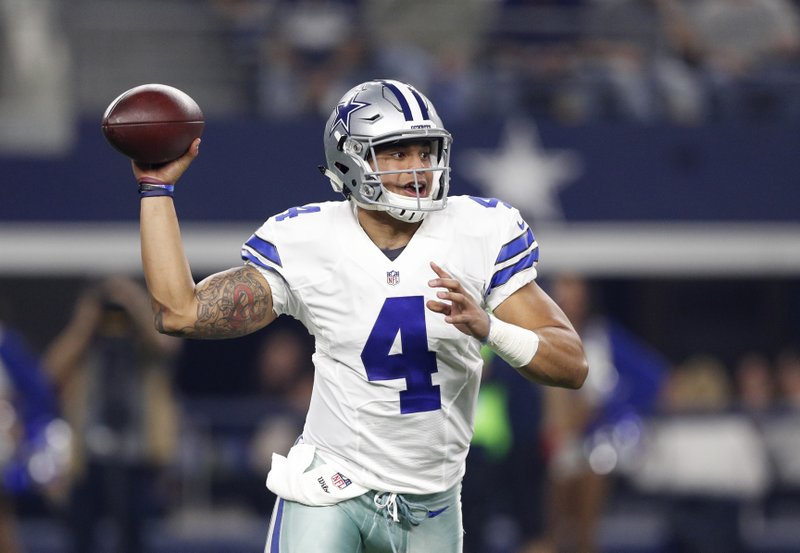 In this Dec. 26, 2016, file photo, Dallas Cowboys' Dak Prescott (4) throws a pass in the first half of an NFL football game against the Detroit Lions, in Arlington, Texas. 