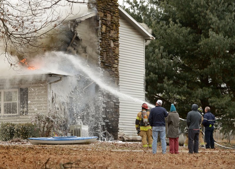 Firefighters from multiple departments battle a house fire on Friday Jan. 6, 2017 at 701 McCann Rd. in Benton County near Rogers.