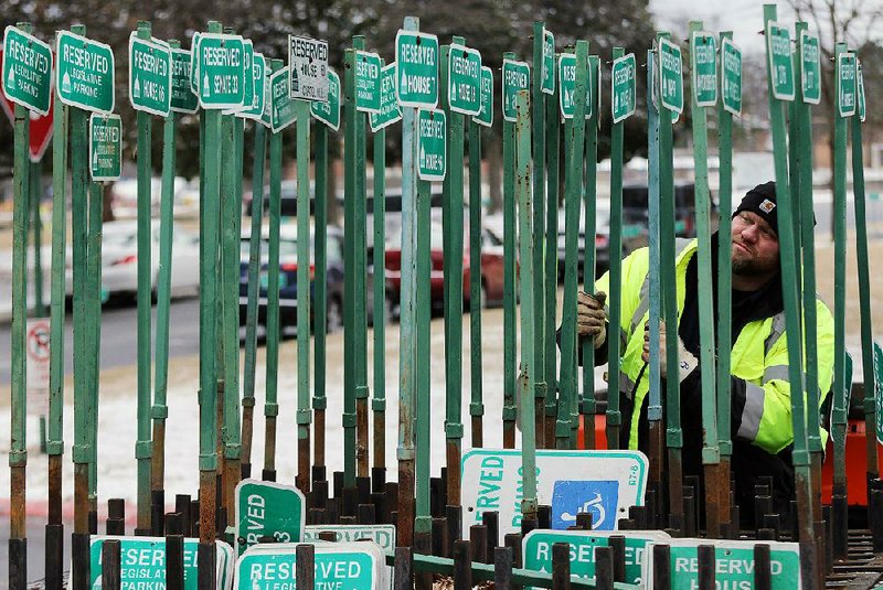 Kevin Brown, a member of the grounds maintenance crew at the state Capitol, organizes parking signs Friday in preparation for the legislative session that begins Monday.