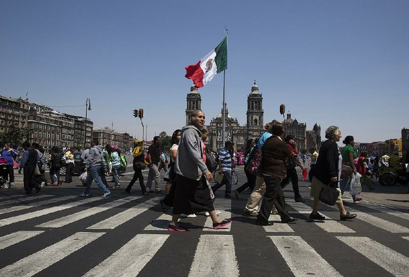 People walk by the Metropolitan Cathedral in Mexico City last year. Some economists have cut their forecasts for Mexico’s GDP growth this year.