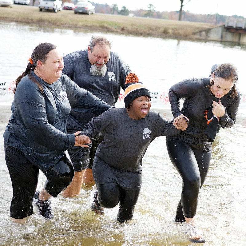 From left, Glenda and Chuck Gregory of Birdtown exit the water with Julie Grantham, 13, and Janis Masters, both of Bryant, at the Polar Plunge at Lake Willastein in Maumelle on Dec. 10. On Tuesday, Special Olympics Arkansas will hold a Polar Plunge at Mountain View High School.