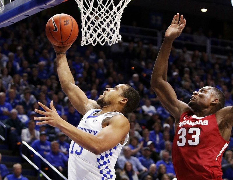 Kentucky's Isaiah Briscoe, left, shoots while defended by Arkansas' Moses Kingsley (33) during the first half of an NCAA college basketball game, Saturday, Jan. 7, 2017, in Lexington, Ky. (AP Photo/James Crisp)