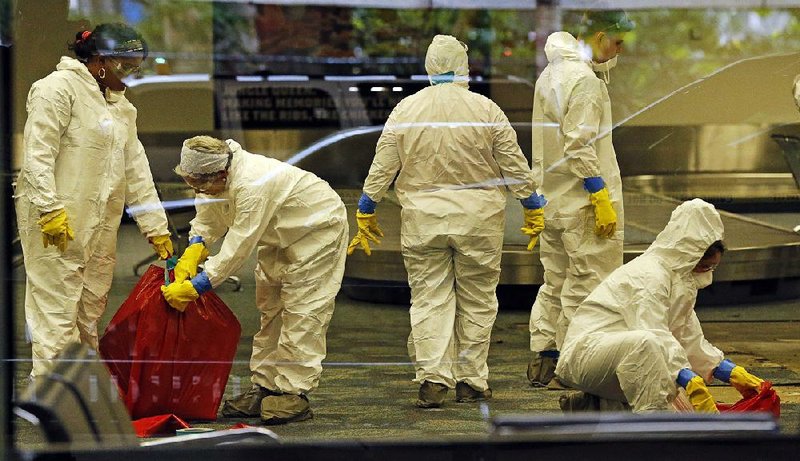 A hazardous-materials team cleans the baggage claim area Saturday at Terminal 2 of Fort Lauderdale-Hollywood International Airport in Florida, where a gunman opened fire Friday.