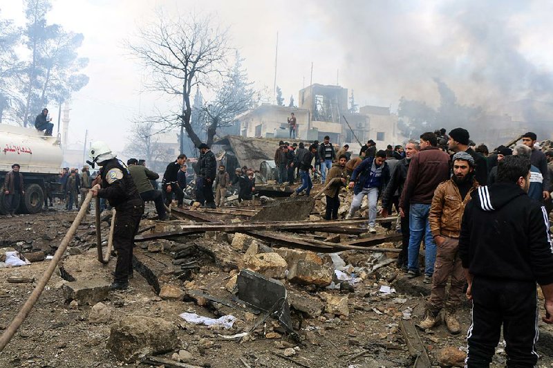 Rescuers work Saturday at the scene where a bomb went off in a busy market in Azaz, Syria, killing dozens of people. 