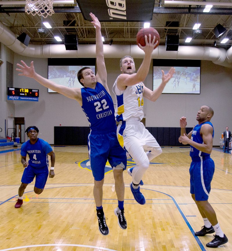 Photo courtesy of JBU Sports Information John Brown sophomore guard Jake Caudle goes to the basket as Southwestern Christian&#8217;s Casey Cole defends during Thursday&#8217;s basketball game at Bill George Arena. Southwestern Christian defeated the Golden Eagles 77-65.