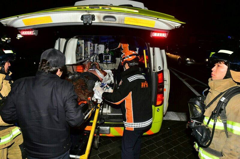 In this Saturday, Jan. 7, 2017 photo, an injured Buddhist monk who set himself on fire is put into an ambulance in Seoul, South Korea. The South Korean Buddhist monk is in critical condition after setting himself on fire to protest the country's settlement with Japan on compensation for wartime sex slaves, officials said Sunday.