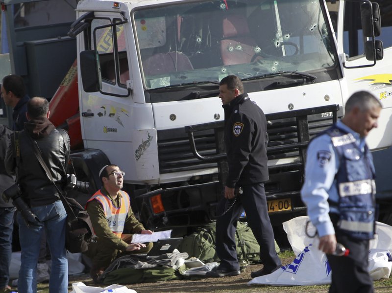 Israeli police investigates the scene of an attack in Jerusalem Sunday, Jan. 8, 2017. A Palestinian rammed his truck into a group of Israeli soldiers in Jerusalem on Sunday, killing four people and wounding 15 others, Israeli police and rescue services said, in one of the deadliest attacks of a more than yearlong campaign of violence. 