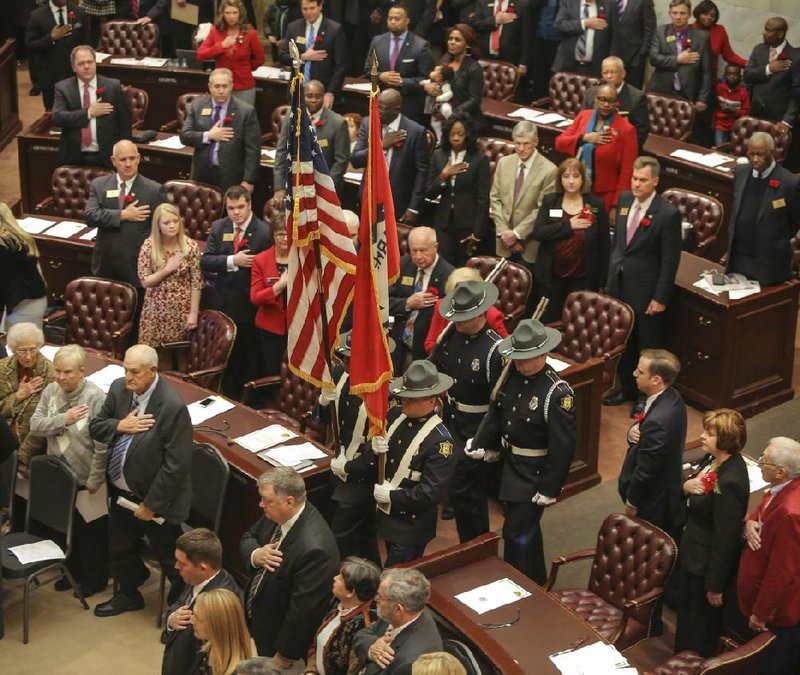 Lawmakers stand at attention Monday while the Arkansas State Police honor guard posts the colors as the 91st General Assembly convenes at the state Capitol in Little Rock. More photos are available at arkansasonline.com/galleries.