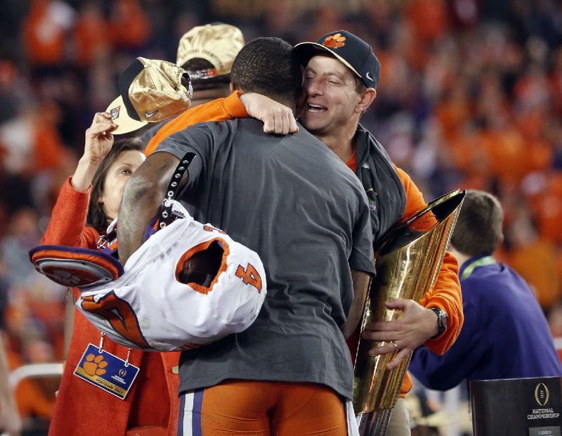 Clemson Coach Dabo Swinney hugs Tigers quarterback Deshaun Watson and the national championship trophy after Monday night’s 35-31 victory over Alabama.