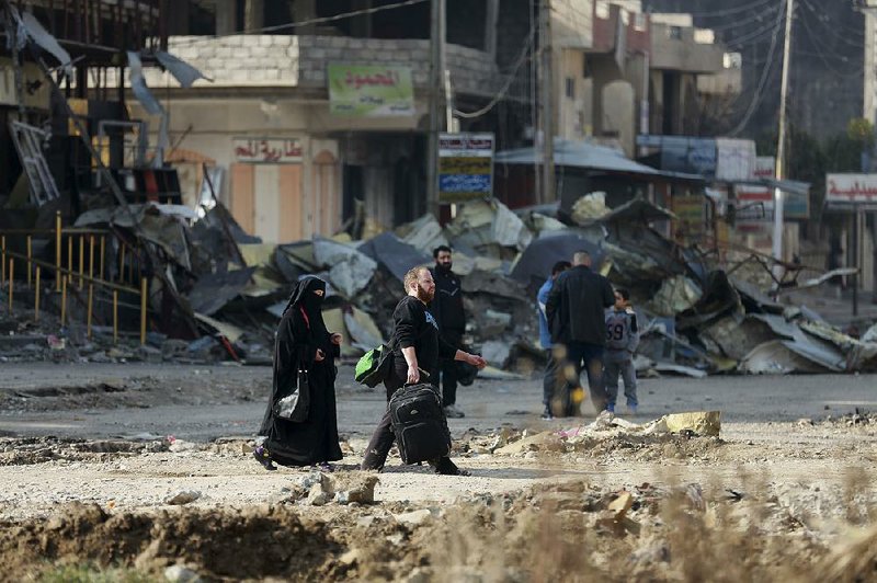 Civilians leave their neighborhoods as Iraqi security forces and Islamic State militants battle Monday in Mosul.