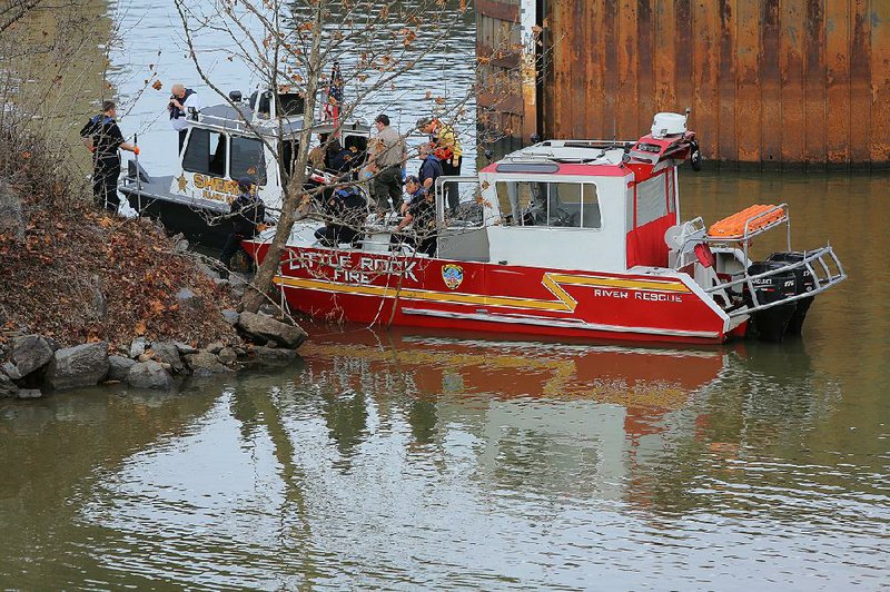 1/10/17
Arkansas Democrat-Gazette/STEPHEN B. THORNTON
Crews from the Pulaski County Sheriff's department, left, and Little Rock Fire Department, right, examine the area where they discovered a body floating in the Arkansas River Tuesday afternoon just west of I-30 in downtown Little Rock.