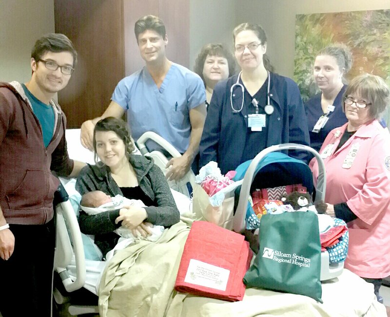 Submitted Photo The first baby of the new year at Siloam Springs Regional Hospital arrived on Jan. 3, 2017, at 4:10 a.m. Oliver was greeted with a special New Year&#8217;s Baby package which included a special blanket from the Siloam Springs Dogwood Quilter&#8217;s Guild and gifts from the SSRH Auxiliary. Pictured are proud parents Denver and Bethany with baby Oliver (left), Dr. Chad Hill, Loretta Jordan, Teresa Teed, Keesha Murray and Barbara Johnson.