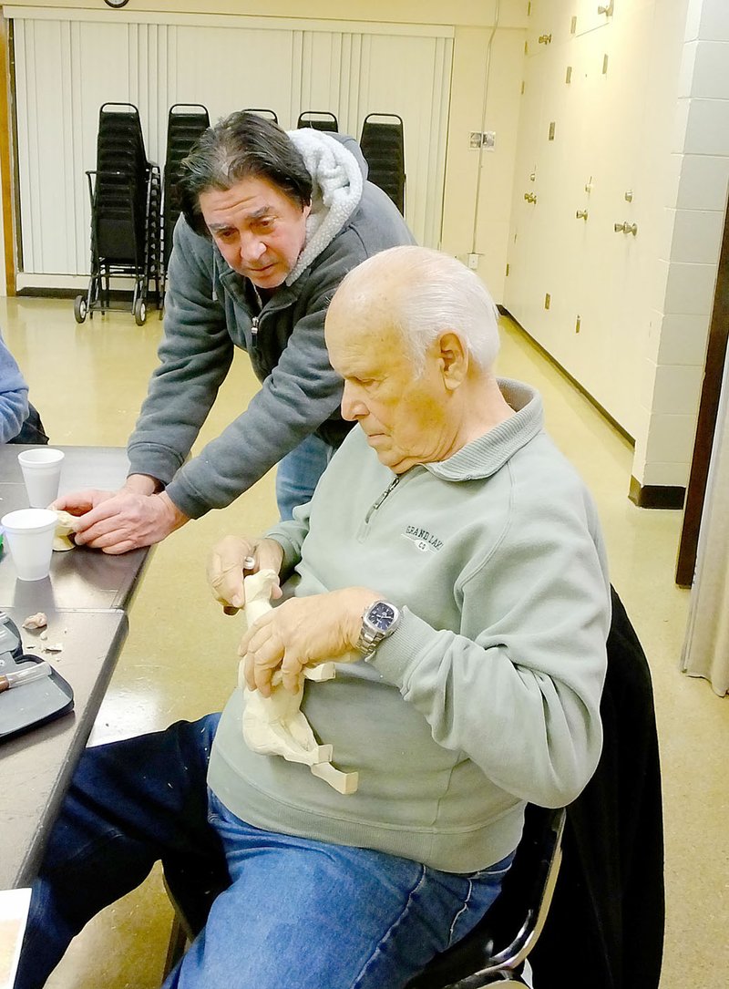 Lynn Atkins/The Weekly Vista Don Effinger works on a horse carving while new member Tom Diepenbrock watches. Most of the members work on their own projects during the Thursday afternoon meetings.