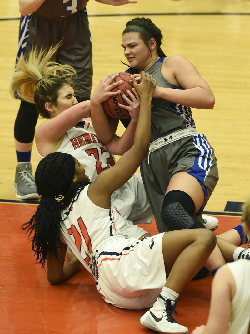 NWA Democrat-Gazette/MICHAEL WOODS @NWAMICHAELW Madison Sherrill, Rogers forward (25) tries to get the rebound from Heritage defenders Hannah Watkins (23) and Kayla Richardson (21) Tuesday, January 10, 2017 during their game at Heritage High School in Rogers.