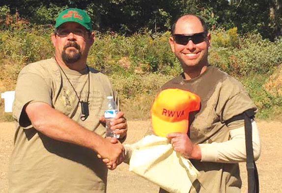 Tom Wall, shoot boss and coordinator for Project Appleseed-Arkansas, left, congratulates Kyle Love of Cabot, a Project Appleseed instructor, on shooting a Rifleman score and accepting a position as an instructor in training.