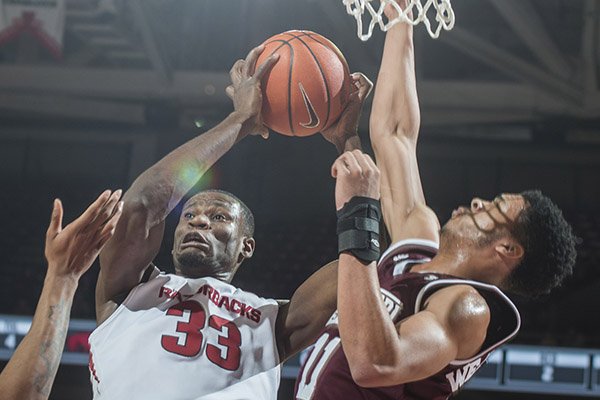 Arkansas' Moses Kingsley (33) comes down with a rebound against Mississippi State's Quinndary Weatherspoon during a game Tuesday, Jan. 10, 2017, in Fayetteville. 