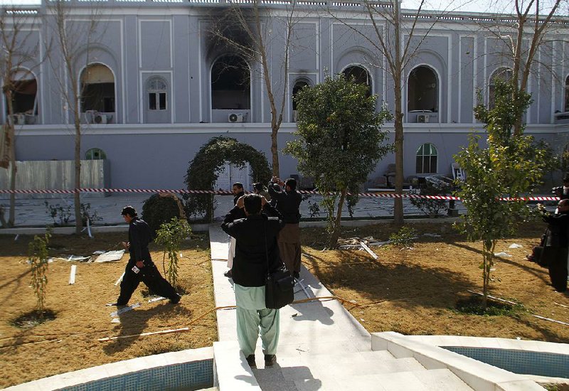 Journalists in Kandahar, Afghanistan, photograph a guesthouse Wednesday where a bombing the day before killed five United Arab Emirates diplomats.