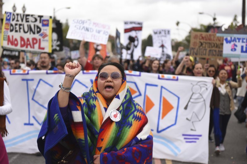 In this Jan. 2, 2017 file photo, protesters rally against the Dakota Access Pipeline behind the 128th Rose Parade in Pasadena, Calif. 