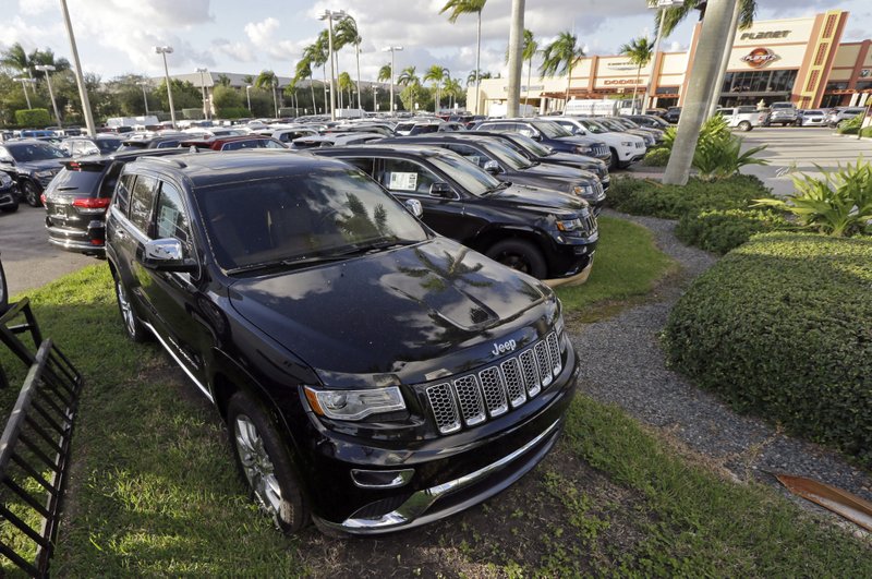 FILE - In this Thursday, Nov. 5, 2015, file photo, 2015 Jeep Grand Cherokees appear on display at a Fiat Chrysler dealership in Doral, Fla. On Thursday, Jan. 12, 2017, the U.S. government alleged that Fiat Chrysler Automobiles failed to disclose that software in some of its pickups and SUVs with diesel engines allows them to emit more pollution than allowed under the Clean Air Act. The Environmental Protection Agency said in a statement that it issued a "notice of violation" to the company that covers about 104,000 vehicles, including the 2014 through 2016 Jeep Grand Cherokee and Dodge Ram pickups, all with 3-liter diesel engines. (AP Photo/Alan Diaz, File)
