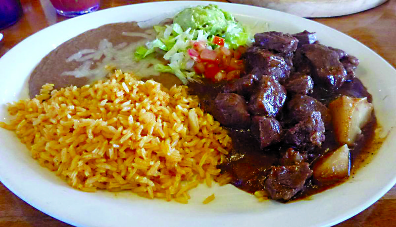Guiso de Res is tender chunks of brisket and potatoes smothered in a spicy sauce, served with lettuce, tomatoes, guacamole, tortillas, rice and beans. It is one of Acapulco&#8217;s specialty dishes.