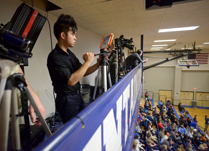 Rogers High senior Hoang Chau, manager for the boys' basketball team, shoots video Jan. 6 of the game against Springdale Har-Ber at King Arena in Rogers.