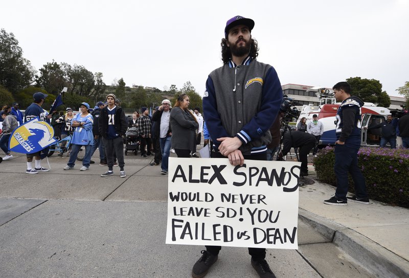 Joseph Macrae holds up a sign in front of of the San Diego Chargers headquarters after the team announced that it will move to Los Angeles, Thursday Jan. 12, 2017, in San Diego. 