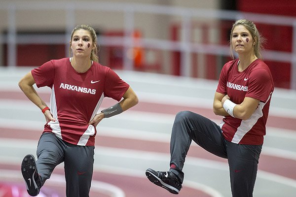 Arkansas sophomore Lexi Weeks (left) and her twin sister, Tori Weeks, watch other pole vaulters compete before entering on Friday, Jan. 13, 2017, during the Arkansas Invitational meet at Randal Tyson Track Center in Fayetteville.