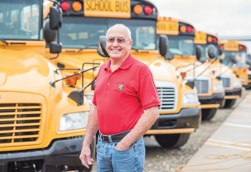 Larry Atkinson stands in front of a row of school buses at the depot where he goes each day to drive a bus for the Searcy School District. Atkinson has been with the district for 17 years and serves in multiple rolls for the district including school-bus driver, cafeteria worker and mailman.