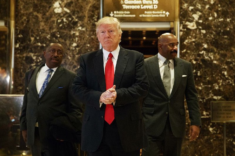 President-elect Donald Trump arrives Friday with comedian Steve Harvey (right) and businessman Greg Calhoun at Trump Tower in New York. Harvey said he was there to discuss inner-city concerns with Trump.