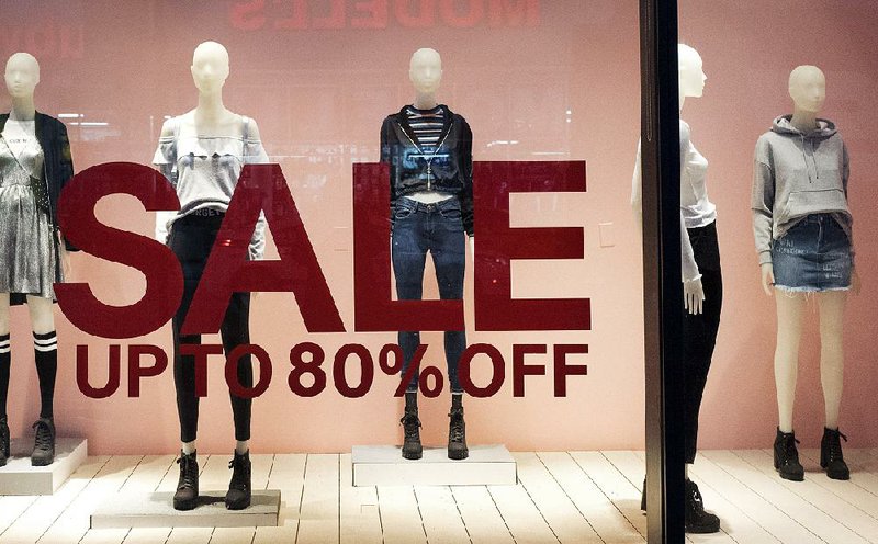 The window of an H&M store in New York advertises a sale this week. Retail sales crept up for December, but clothing retailers recently have been closing stores and cutting jobs