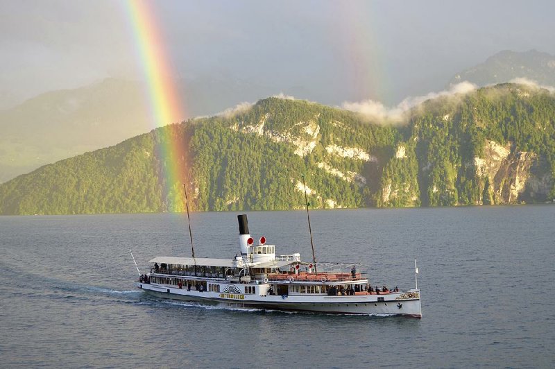 A rainbow stretches in the background as the Unterwalden ferry travels across Lake Lucerne. Cruises run year-round for tourists and for commuters. 