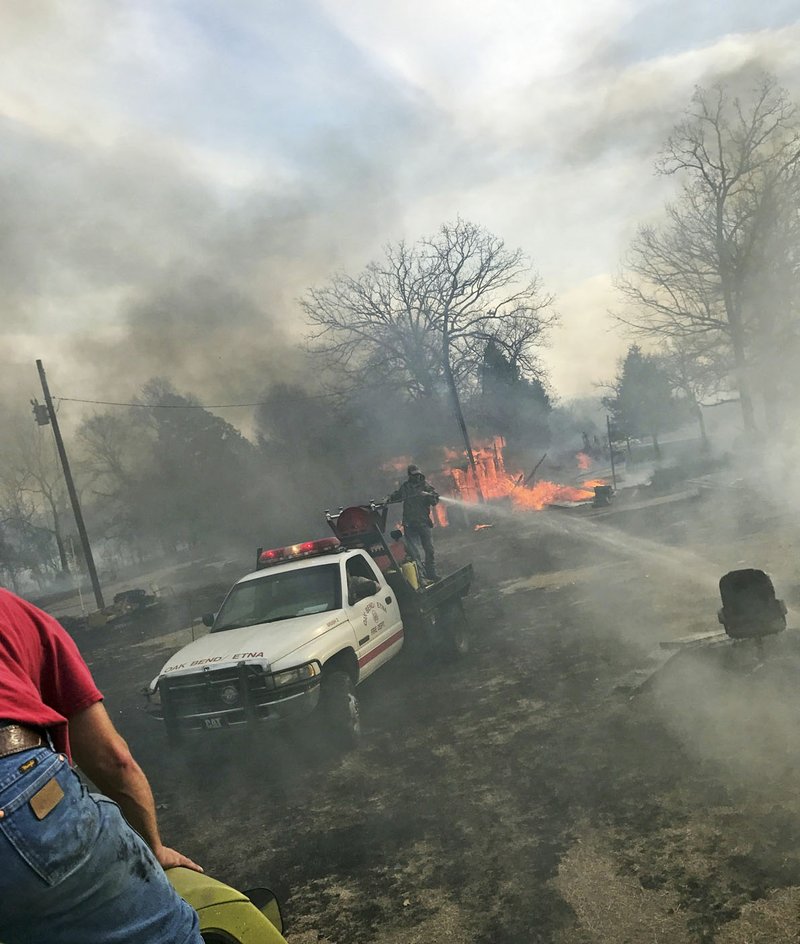 People work to put out a Wednesday wildfire triggered when a pile of chicken manure caught fire in a barn as it threatens property near Charleston in Franklin County. Agriculture experts are warning farmers to make sure their waste piles don’t grow too high because the can catch fire through spontaneous combustion.