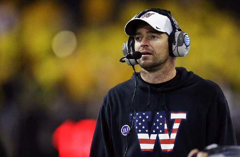  In this Nov. 9, 2013, file photo, Washington defensive coordinator Justin Wilcox wears a sweatshirt and cap with a special team logo to honor veterans as he coaches against Colorado in the second half of an NCAA college football game in Seattle. California changed directions with its football program Saturday, Jan. 14, 2017, hiring Wilcox as head coach to replace the offensive-minded Sonny Dykes. 