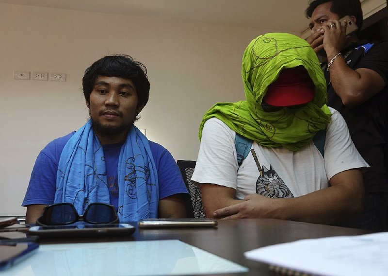 Filipino Glenn Alindajao (left) and South Korean Park Chul-hong prepare to answer questions Saturday in Davao, Philippines, after being released by their captors from the Abu Sayyaf militant group.