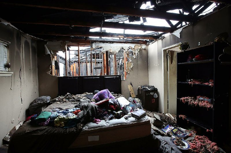 Debris coats the bedroom of a residence Saturday after a fire at Sturbridge Apartments in Little Rock. 
