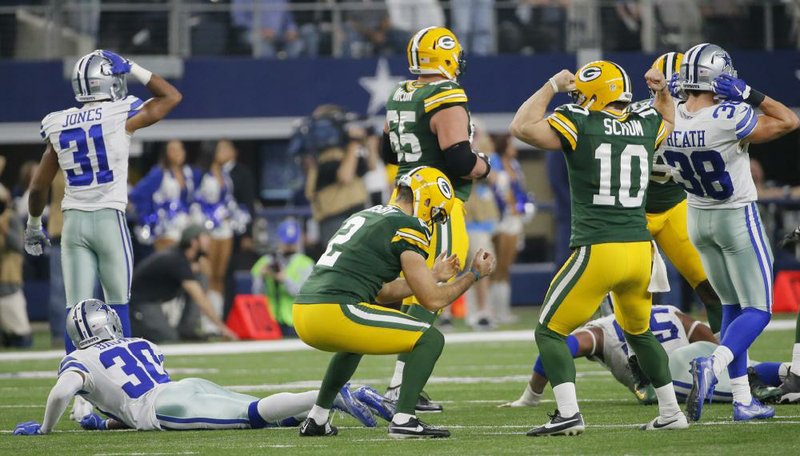 Kicker Mason Crosby (center) reacts after making a 51-yard field goal as time expired to send Green Bay past Dallas 34-31 in an NFC divisional playoff game Sunday and into next week’s conference championship game against Atlanta. Crosby made the kick moments earlier, but it was waved off after the Cowboys called a timeout
right before the snap. After the break, Crosby made the kick again to give the Packers the victory.