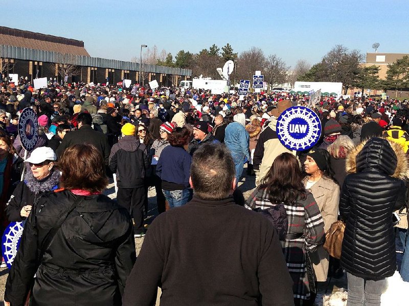 People wait for the start of a health care rally in Warren, Mich., north of Detroit, on Sunday.