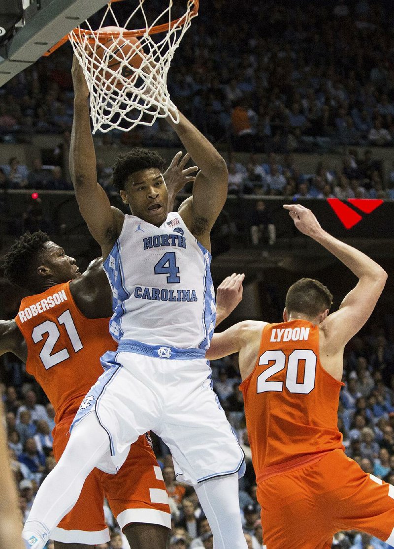 North Carolina forward Isaiah Hicks (center) pulls down a rebound behind Syracuse defenders Tyler Roberson (left) and Tyler Lydon in Monday’s game. Hicks fi nished with eight rebounds and added 20 points in the Tar Heels’ 85-68 victory over the Orange.